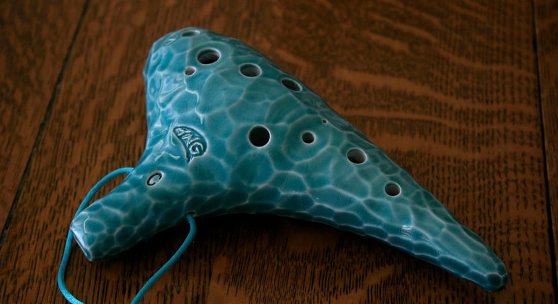 A blue ocarina on a wooden table