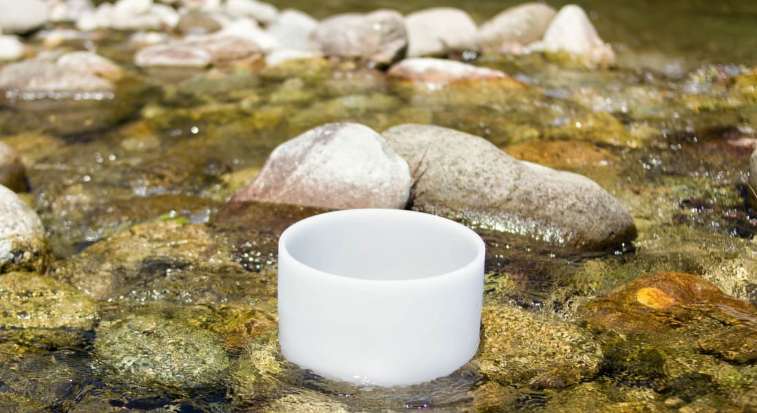 A crystal Tibetan singing bowl soaking in river water