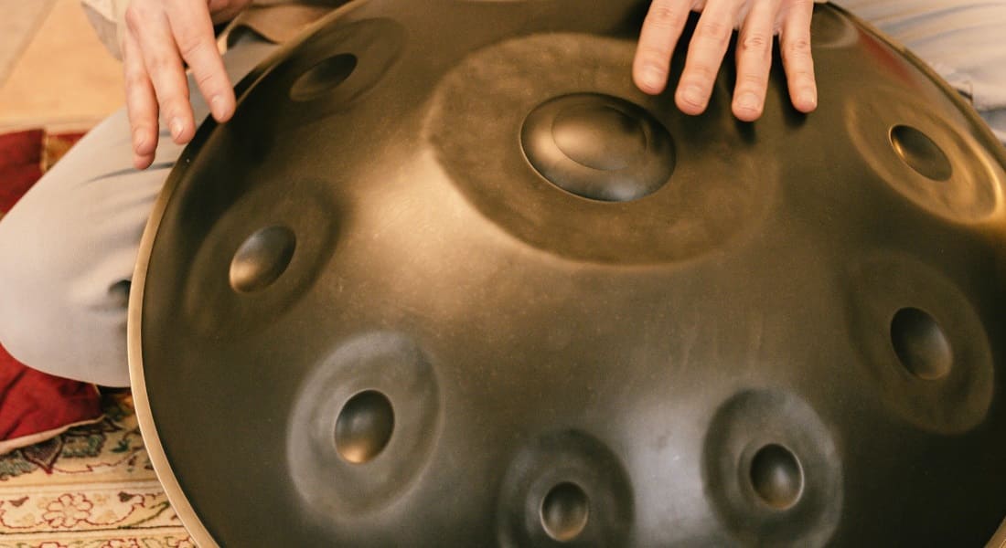 A person playing a 10-note Hang drum