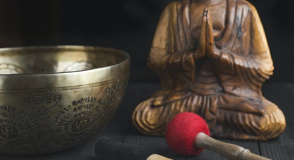 A Tibetan bowl with a wooden Buddha praying