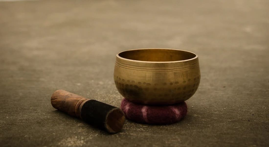 A Tibetan singing bowl placed on a cushion with its mallet