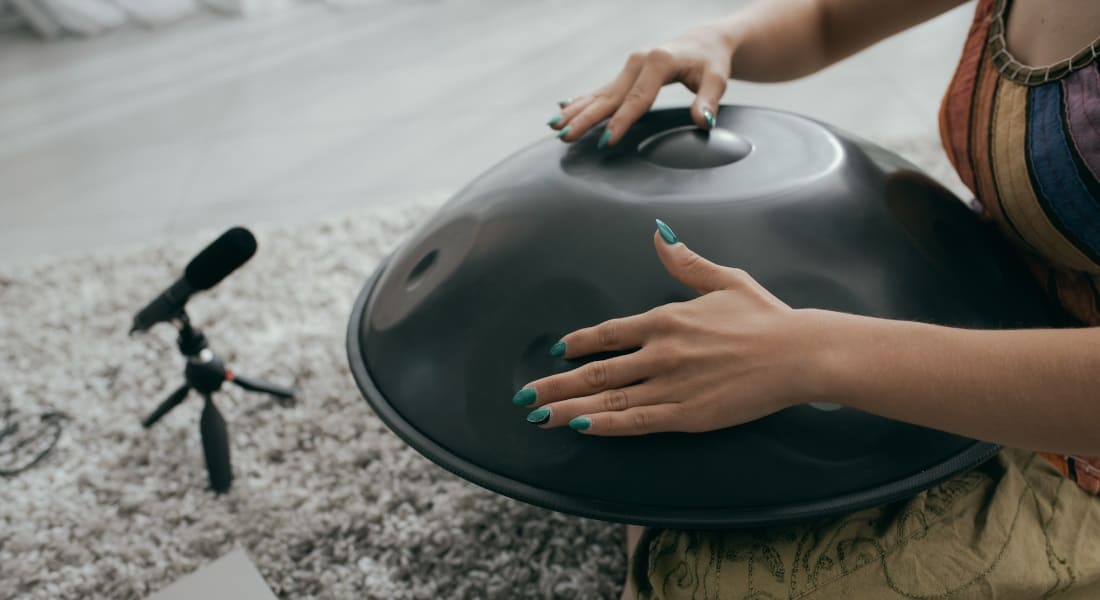 A woman recording her handpan with a mic
