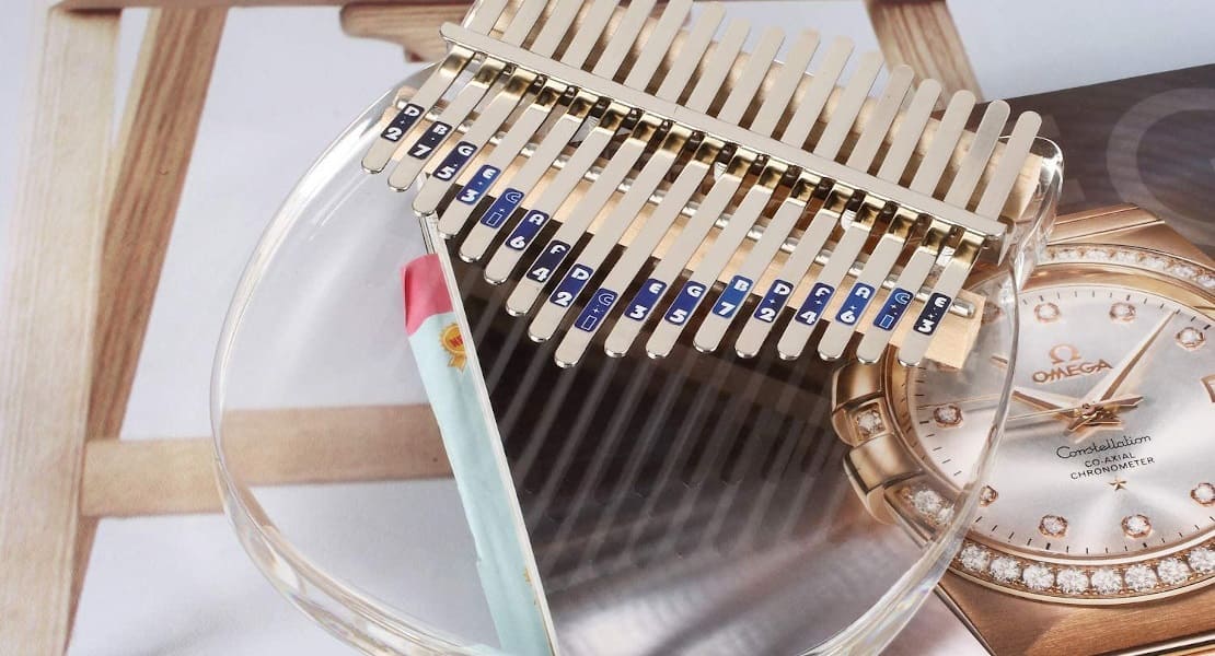 An acrylic kalimba resting on a magazine with no sound hole