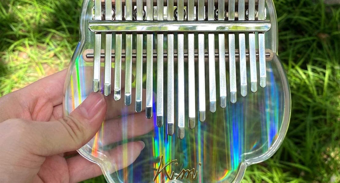 A rainbow acrylic kalimba held in hand