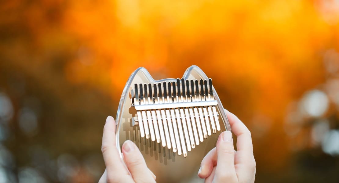 An acrylic thumb piano held by two hands
