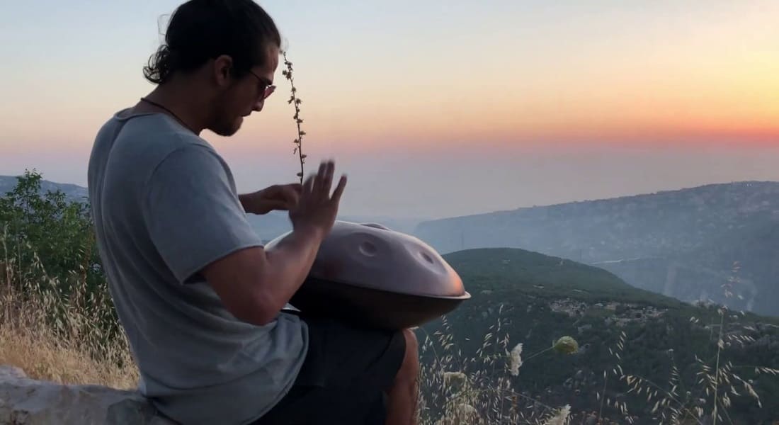 Adam Maalouf playing the handpan on a mountain