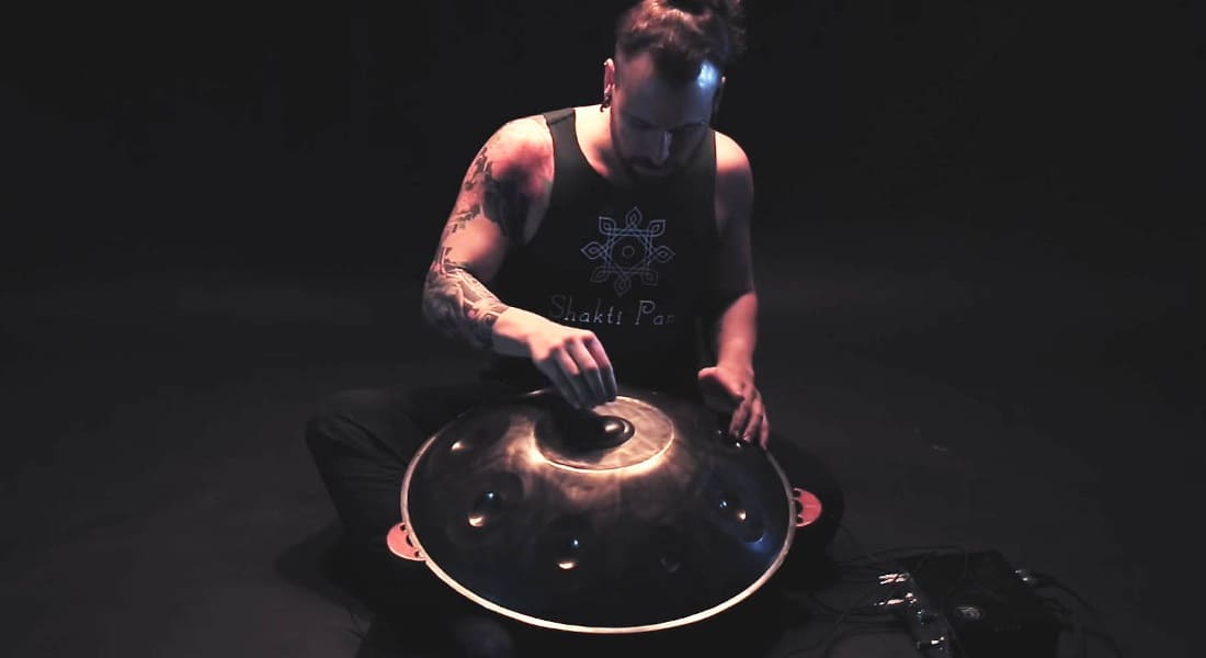 Adrian Portia seated with a handpan