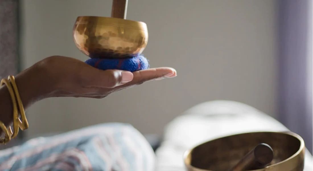 A Black hand holding a singing bowl