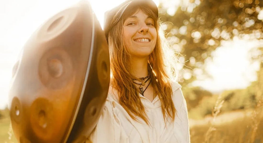 Changeofcolours holding a handpan and smiling