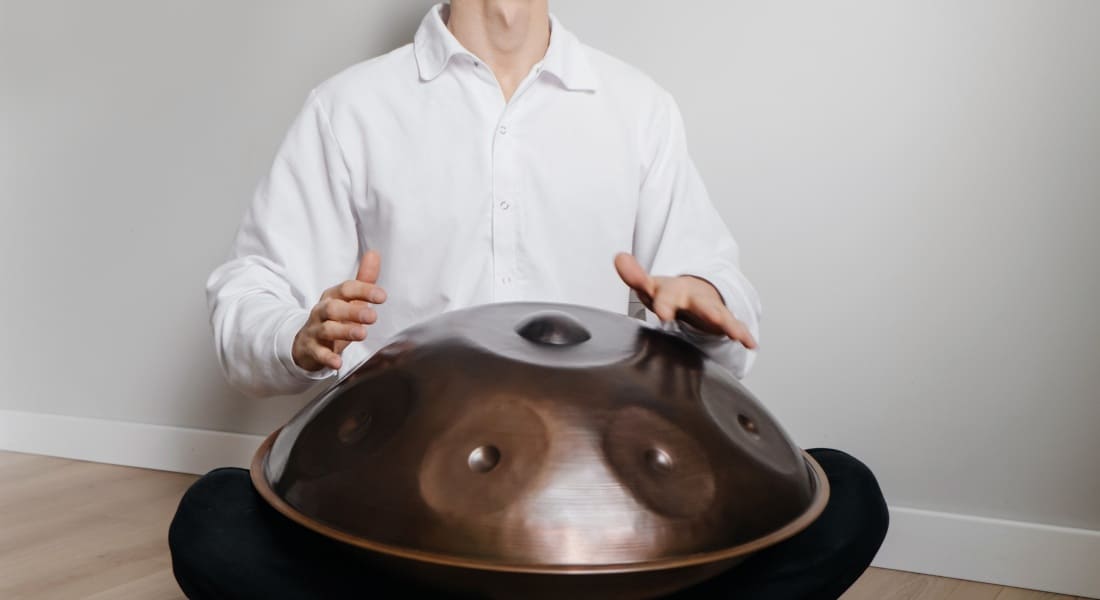 Close-up of a handpan player in a white shirt