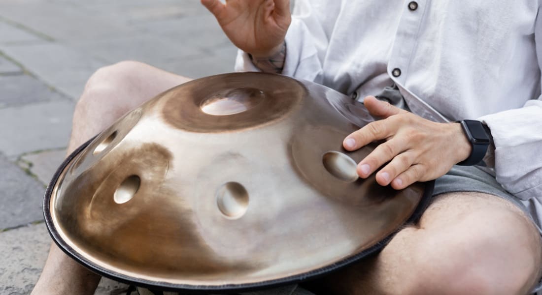 Close-up of a musician with a gold handpan