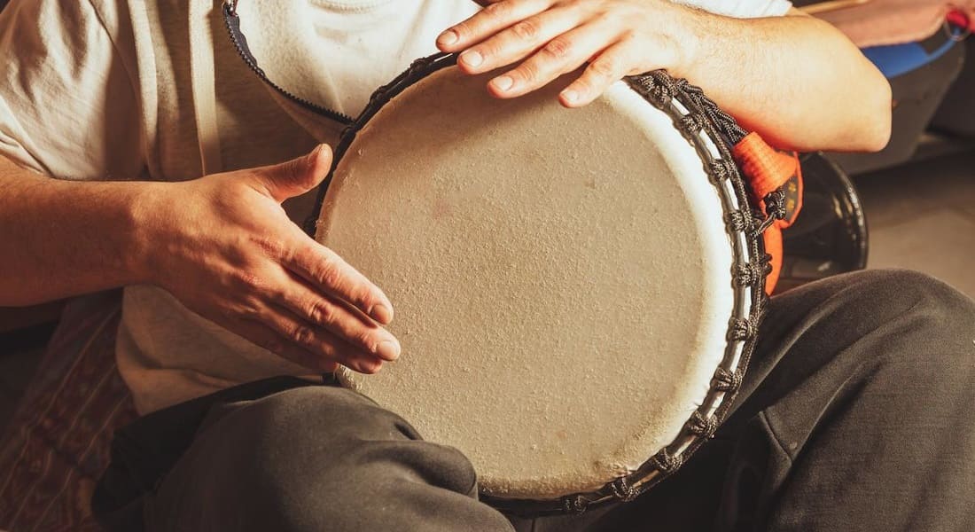 Close-up of two hands playing an African drum
