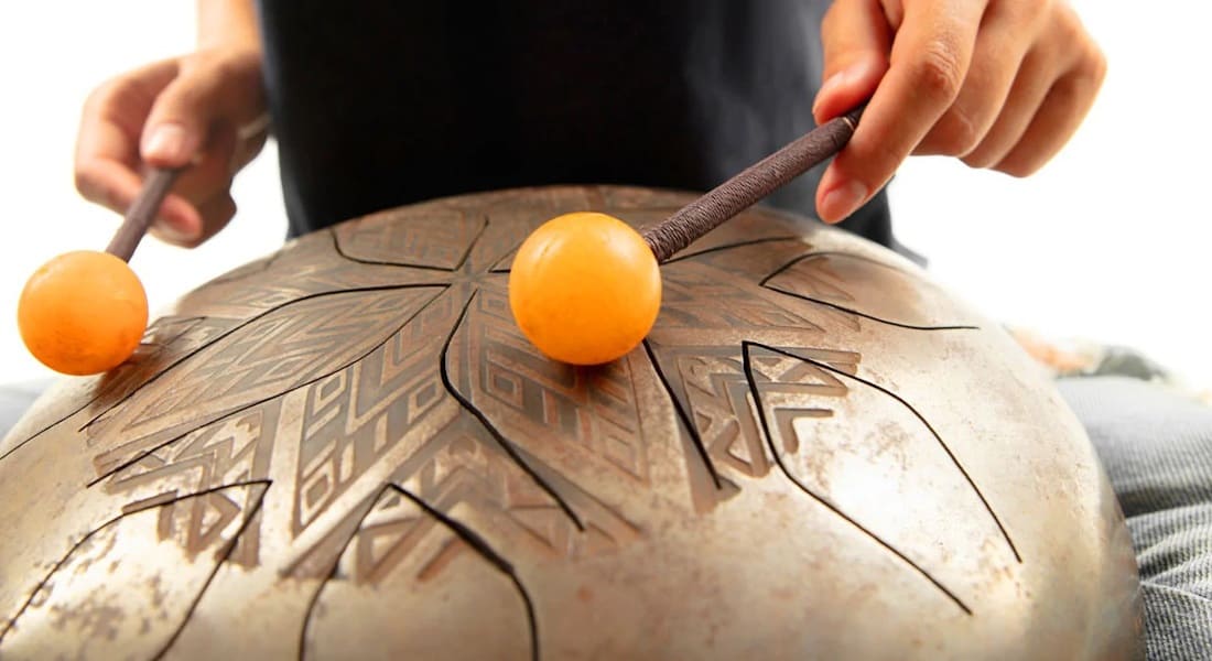 Close-up of a tongue drum player with mallets