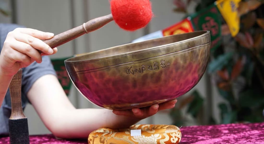 A close-up of a Full Moon Tibetan bowl held in one hand