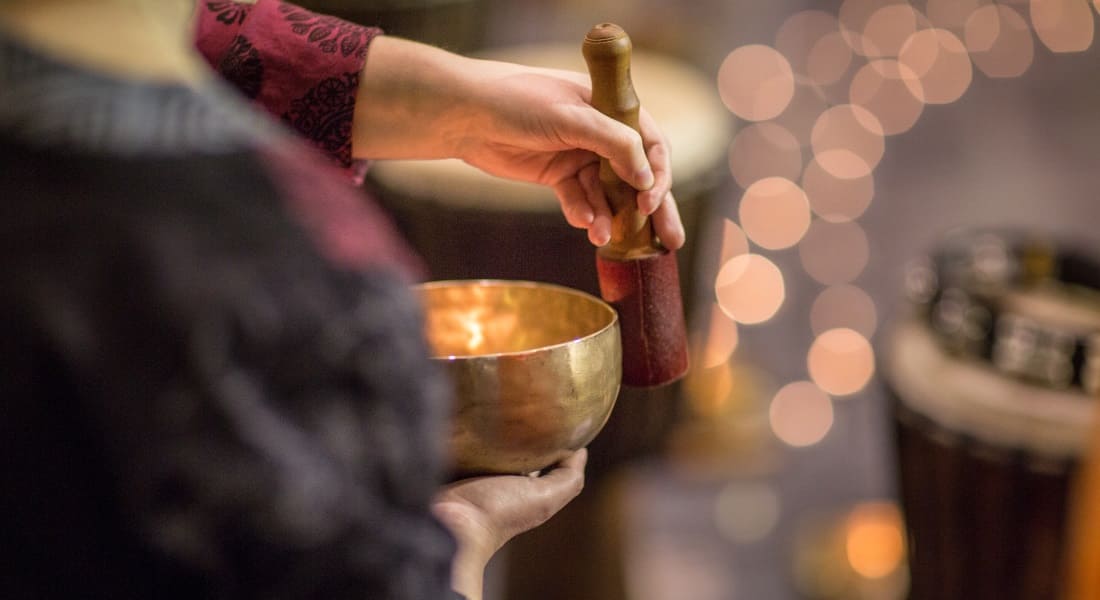 Close-up of a person from behind playing a singing bowl