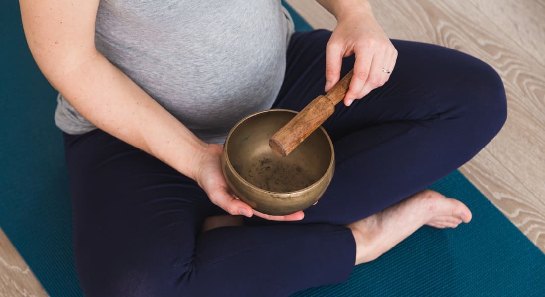 Close-up of a pregnant woman with a singing bowl