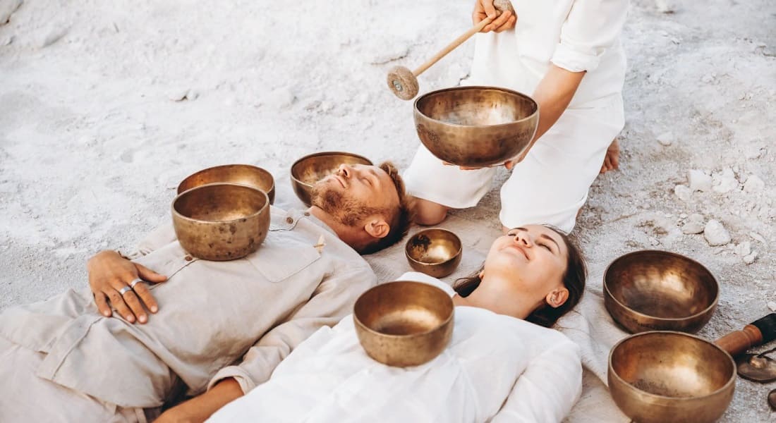 A couple enjoying a sound massage with a Tibetan singing bowl