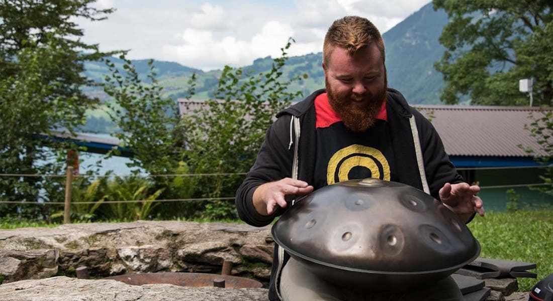 Dan Mulqueen playing handpan on a bench