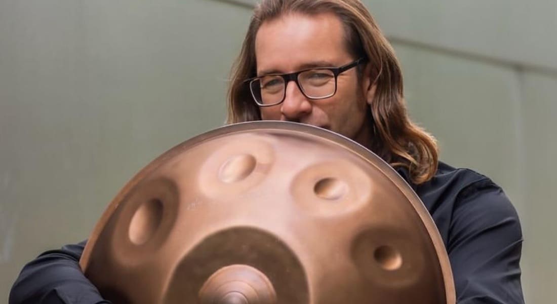 Davide Friello holding a handpan in his arms