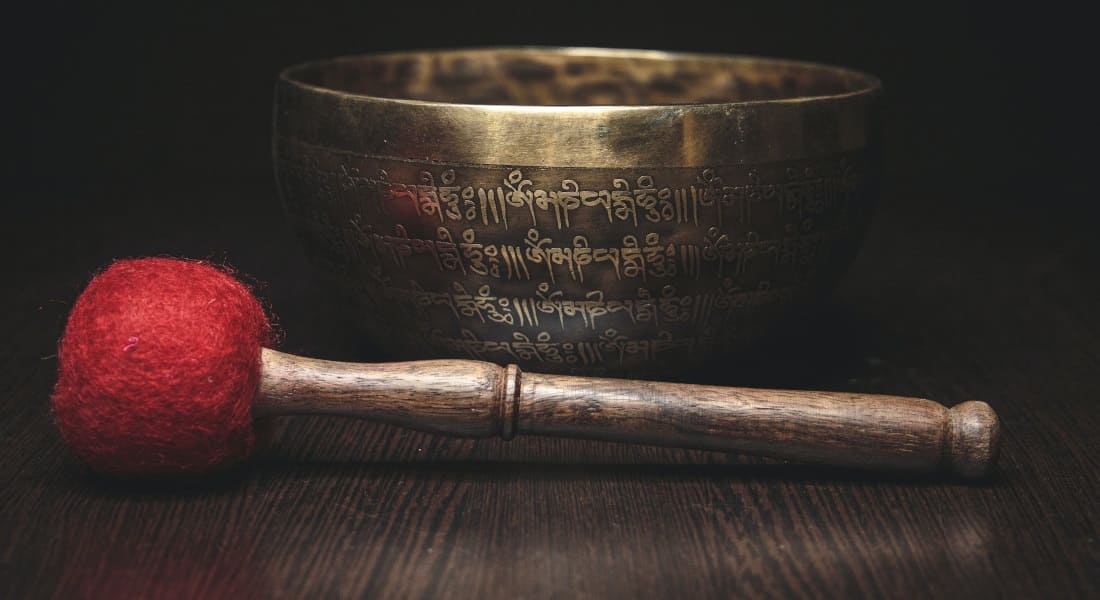An engraved Tibetan bowl with its red mallet