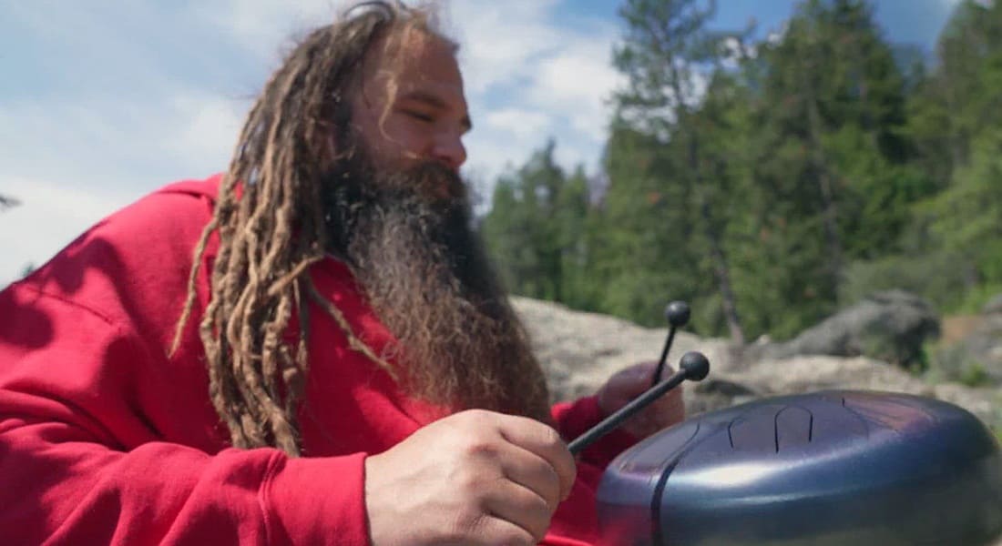 Ethereal in E playing a tongue drum by a lake