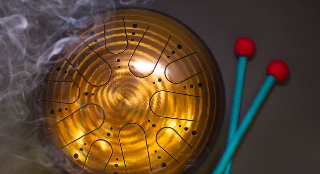 A golden tongue drum surrounded by smoke