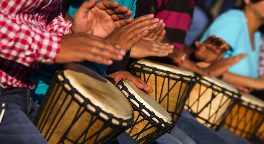 A group of people playing djembe