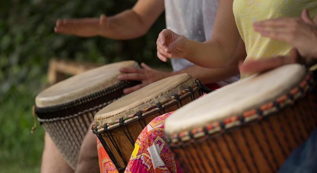 A group of young people playing the djembe