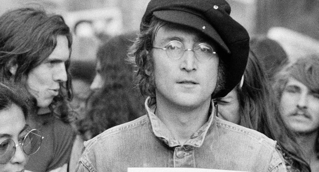 John Lennon standing with a beret