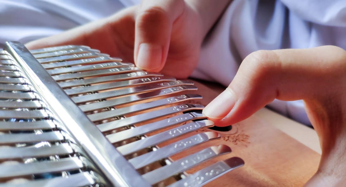 A close-up of a kalimba with hands