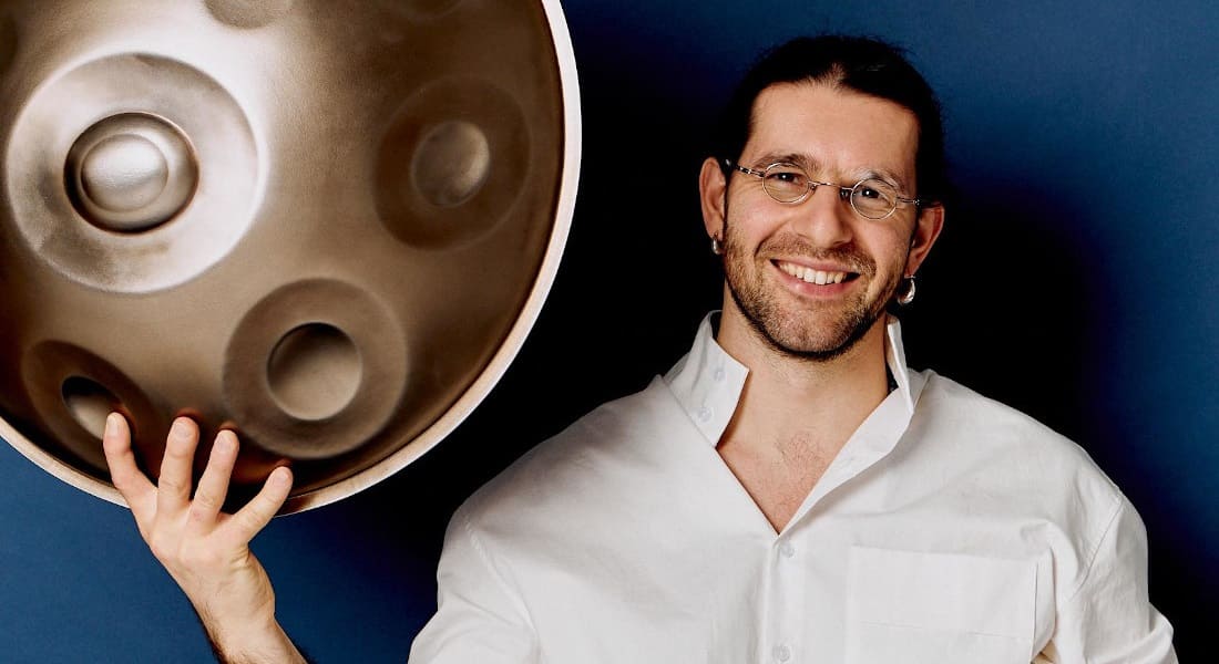 Kirill Osherov holding a handpan in one hand
