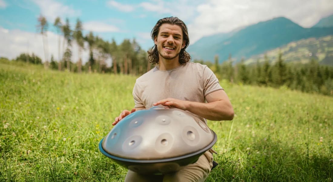 Konstantin Rössler in a meadow playing the handpan