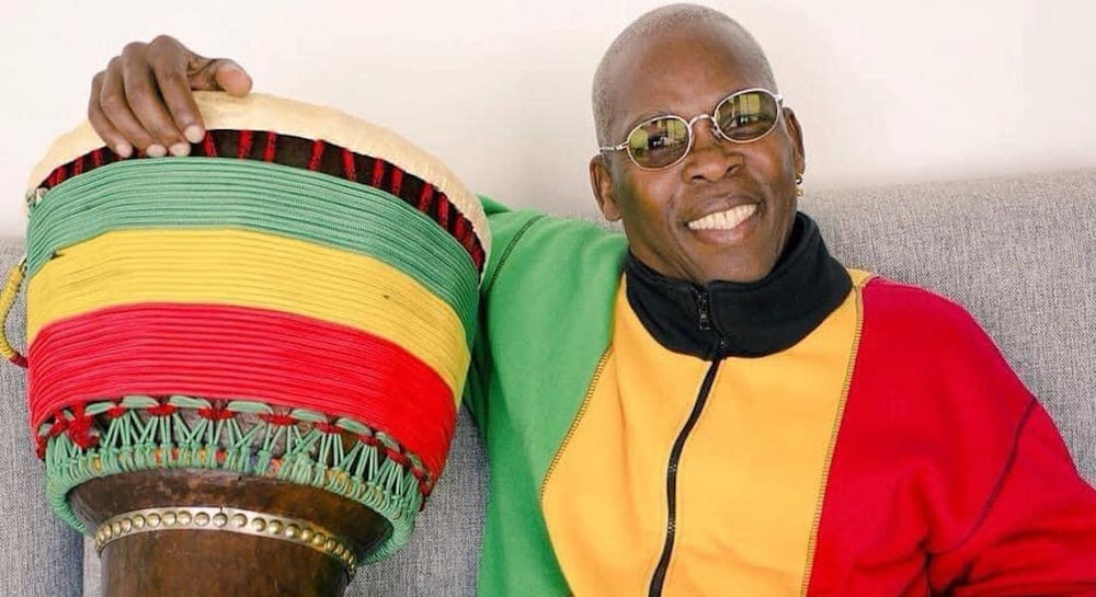 Mamady Keïta sitting on a couch with a djembe