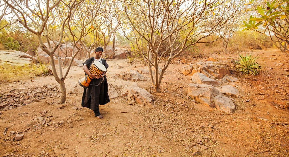 A man alone in the plain with a djembé in his hands