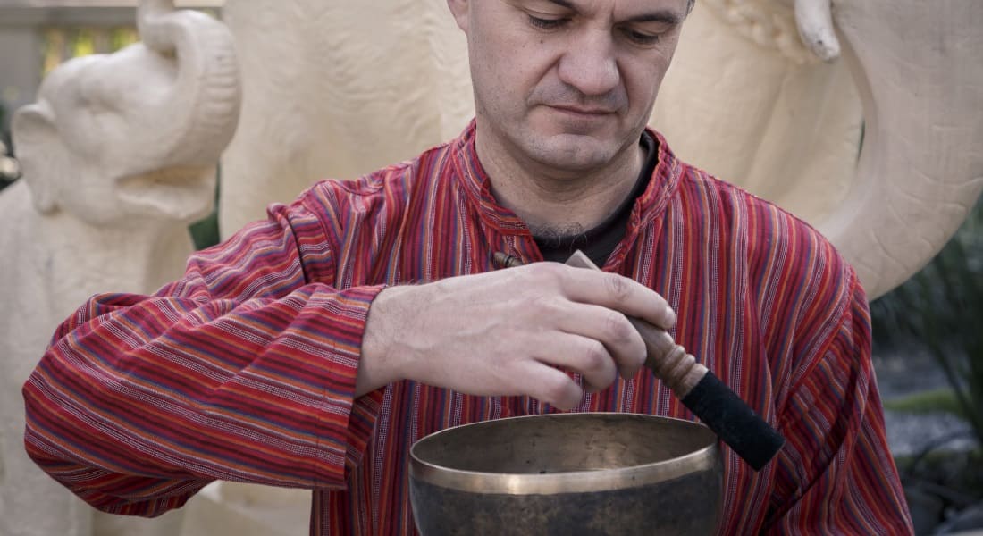 Close-up of a man playing a Tibetan singing bowl