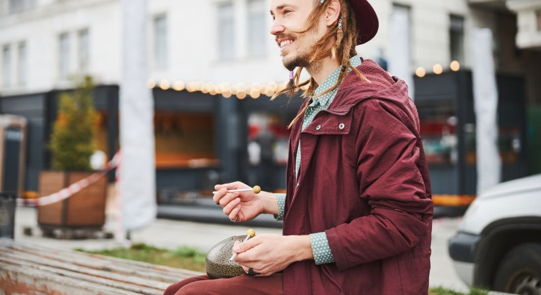A man dressed in red playing the tongue drum with mallets