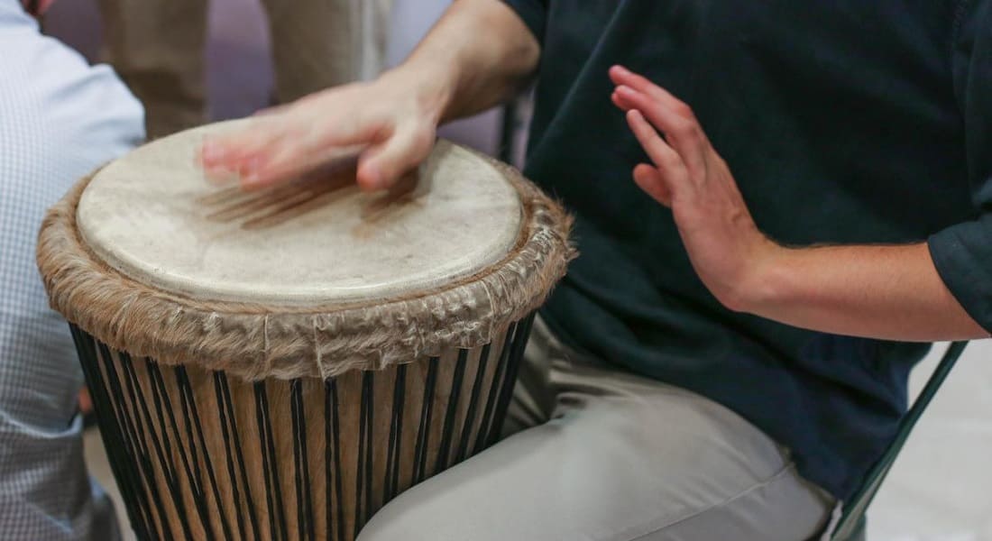 A man sitting on a chair with a drum