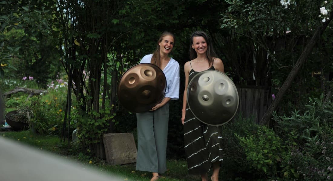 Mea laughing and each carrying a Hang drum