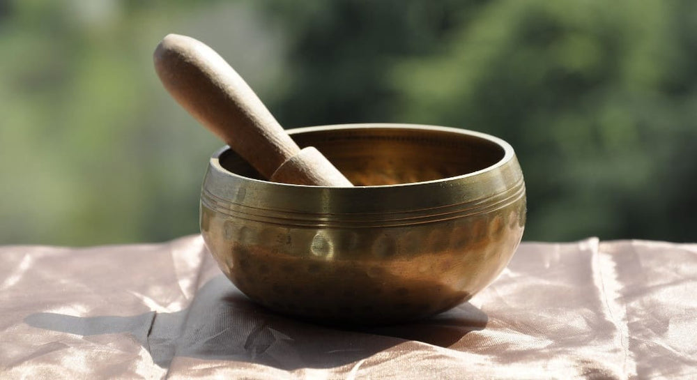 A metal singing bowl with a mallet inside