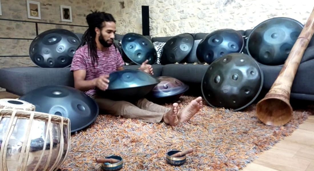 Michaël Akortia seated and surrounded by handpans