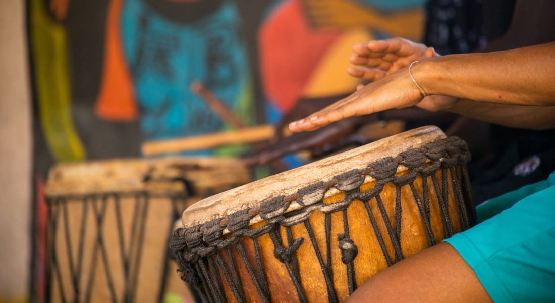 A musician playing a wooden djembe