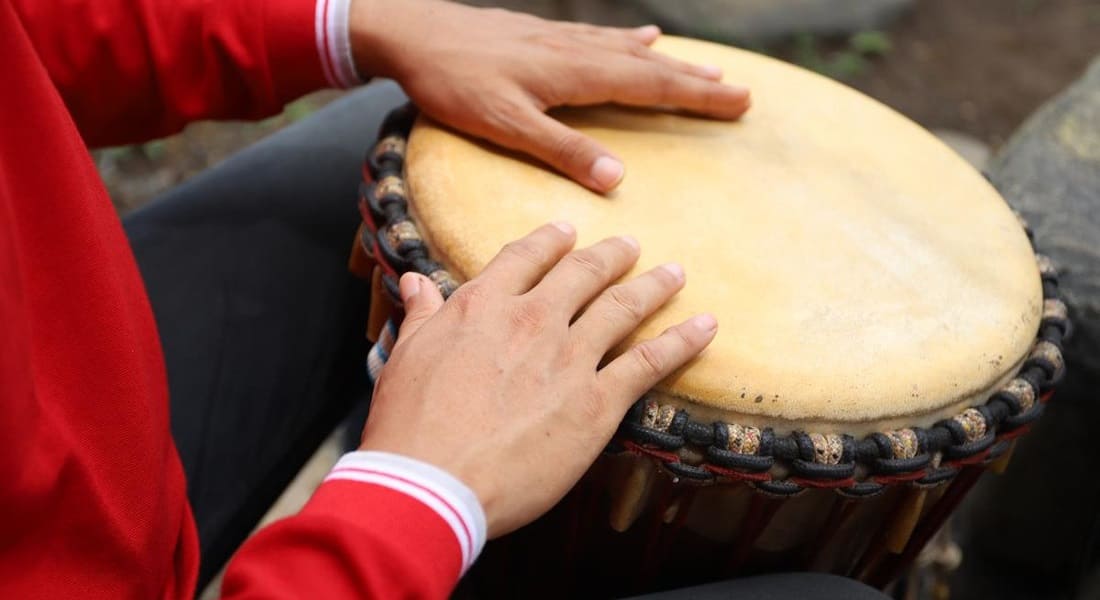A musician striking an African drum