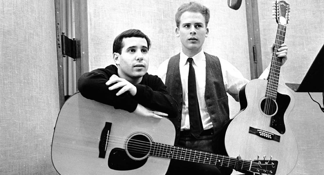 Paul Simon and Arthur Garfunkel each with a guitar