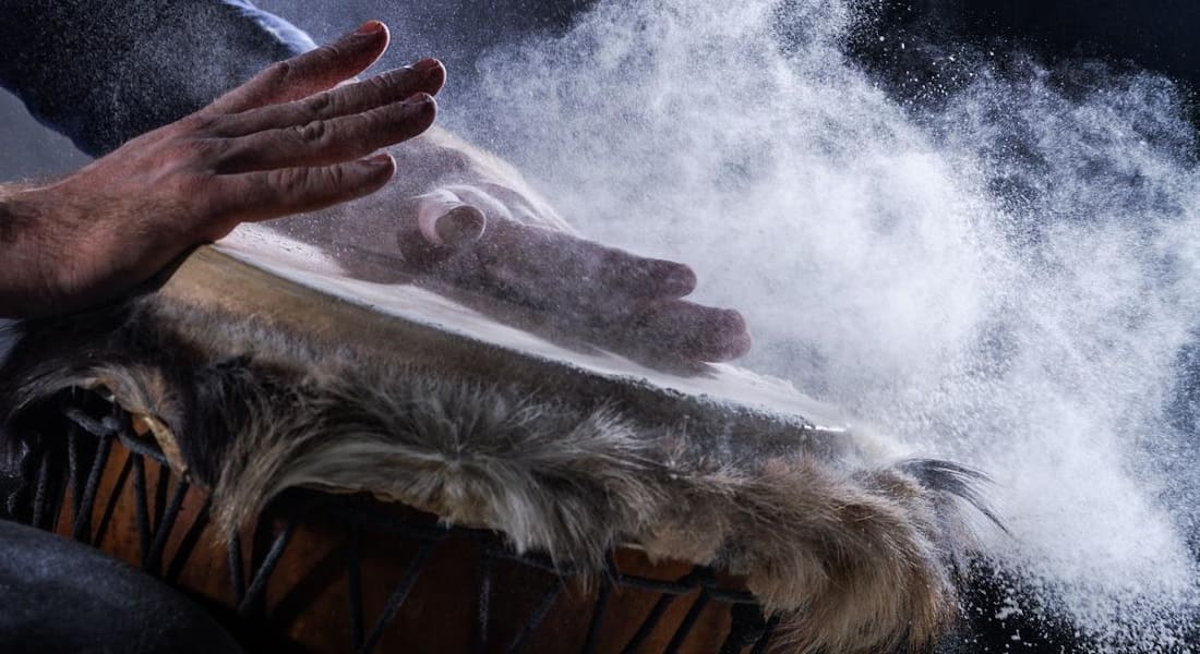 A player hitting a dusty djembe
