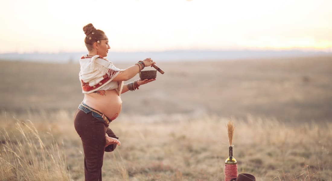 A pregnant woman doing yoga with a Tibetan singing bowl