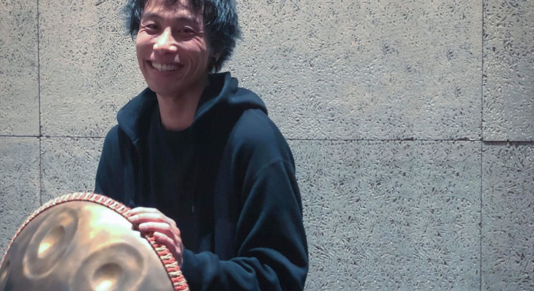 Reo Matsumoto smiling with a handpan