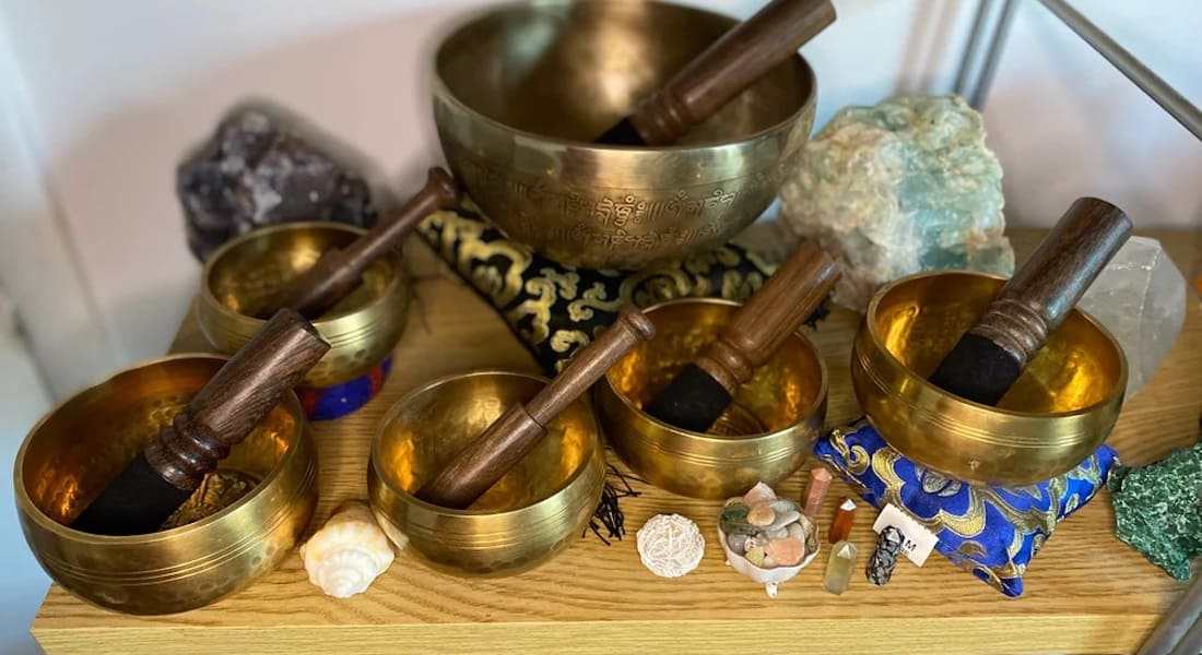 Several singing bowls next to crystals