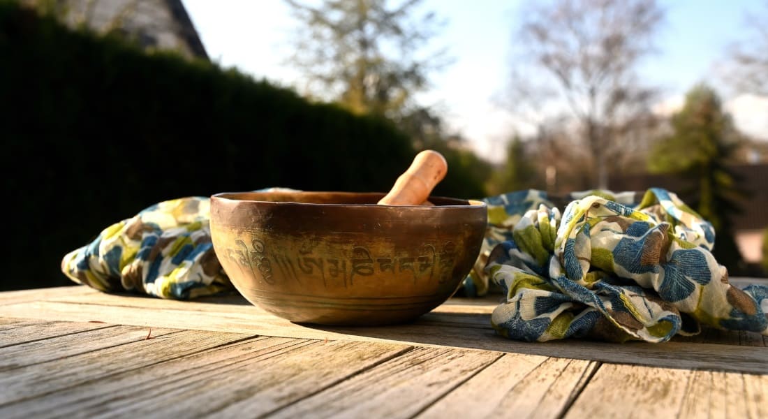 A singing bowl on a table outdoors.