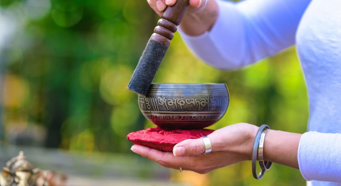 A singing bowl resting on a red cushion