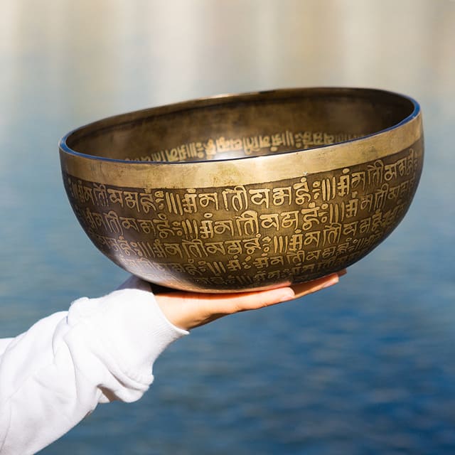 Seven-metal singing bowl held in hand